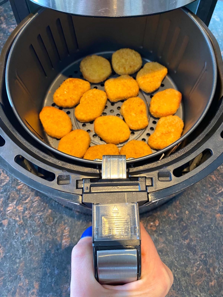 air fryer opened to show Impossible chicken nuggets cooking inside