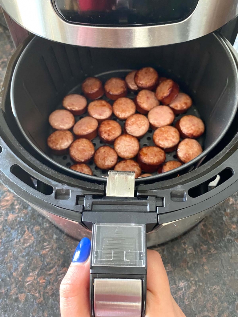 air fryer opened to show slices of kielbasa inside