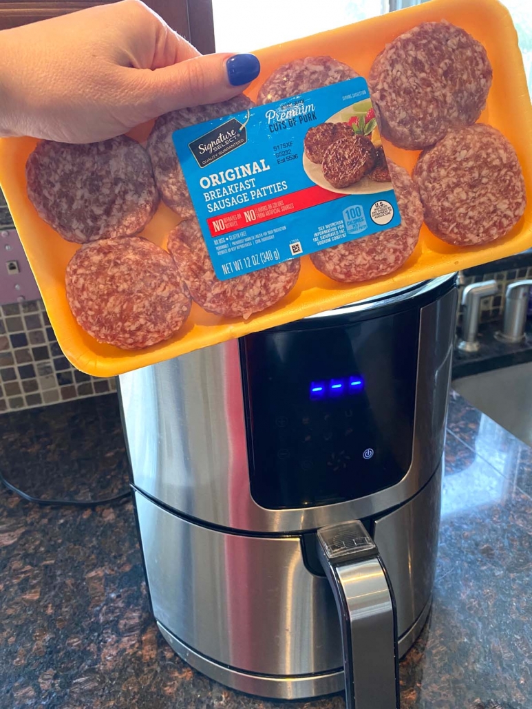 hand holding package of sausage patties in front of air fryer