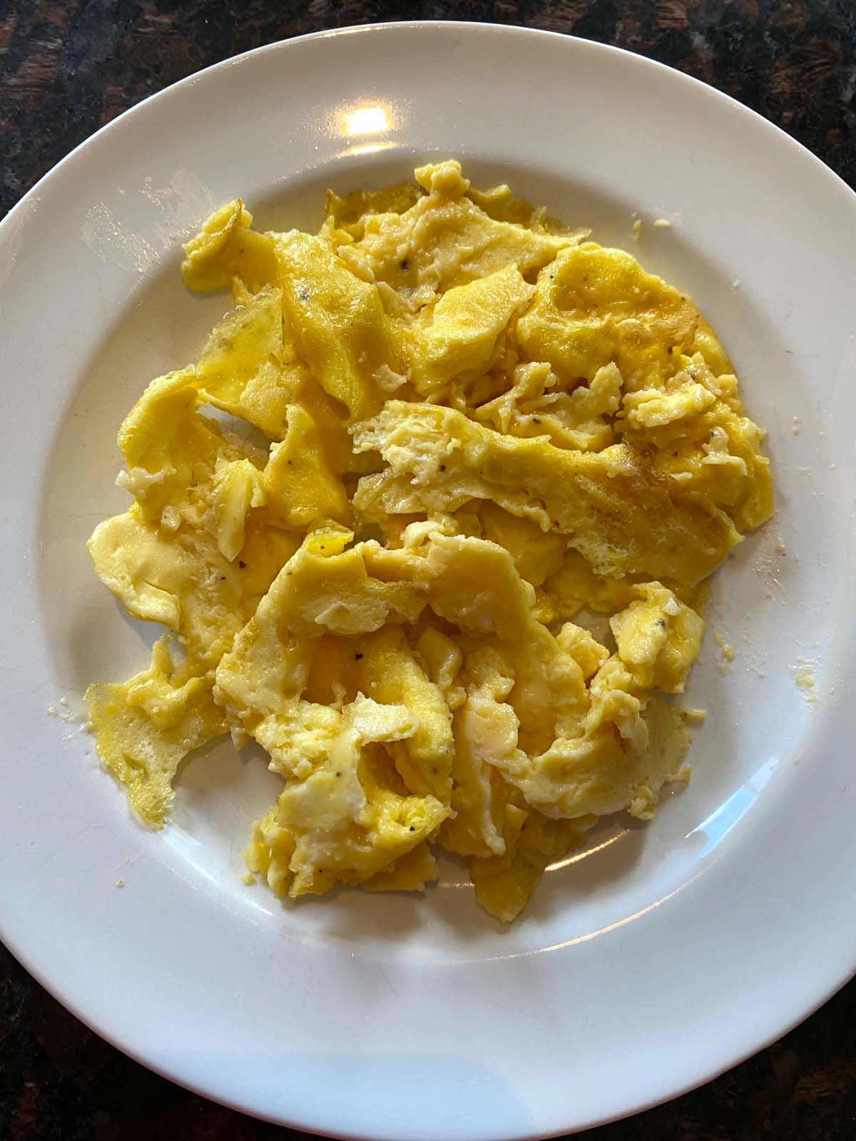 Scrambled eggs on a white plate.