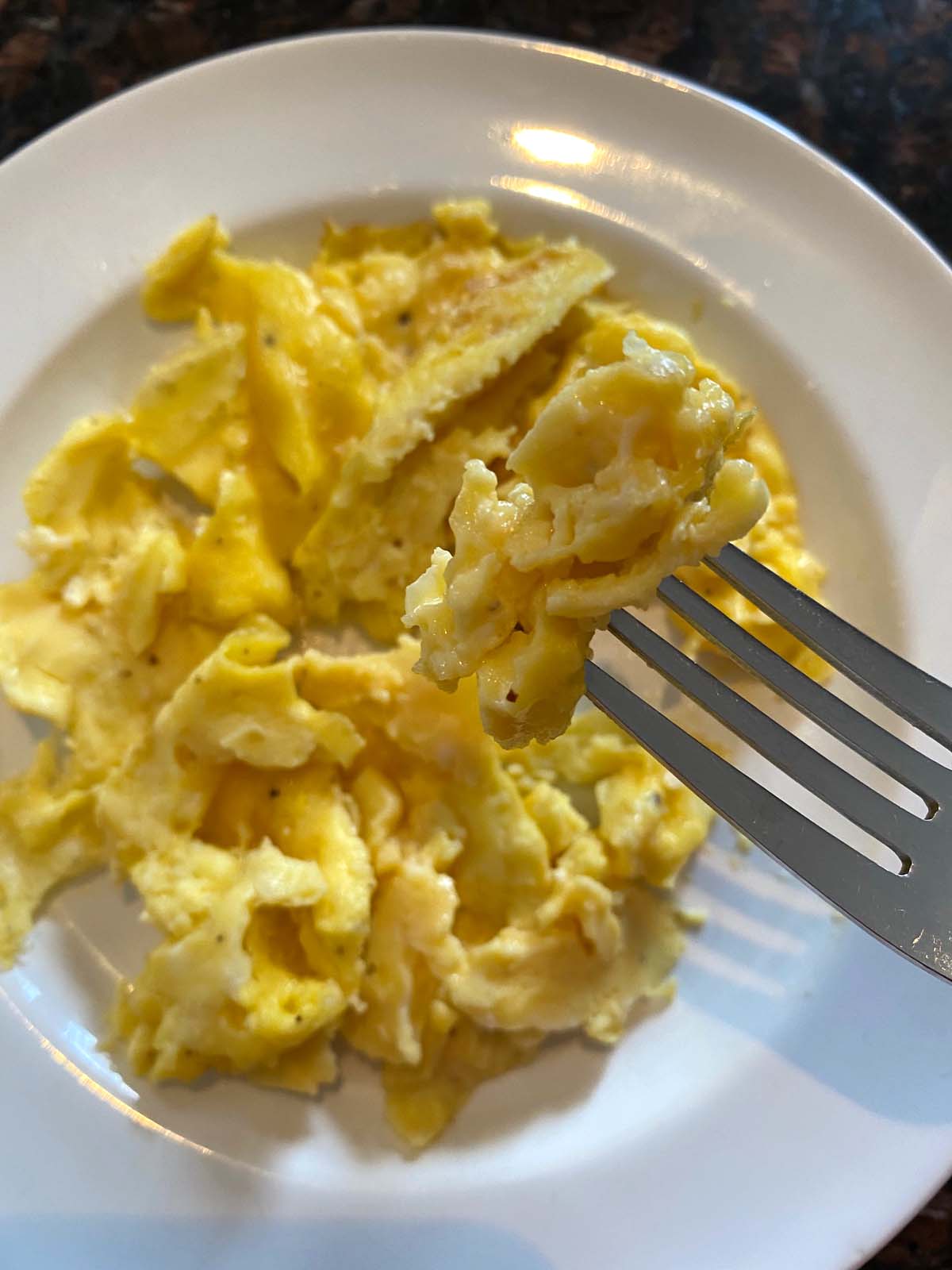 Scrambled eggs on a white plate.