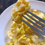 Scrambled eggs on a white plate.