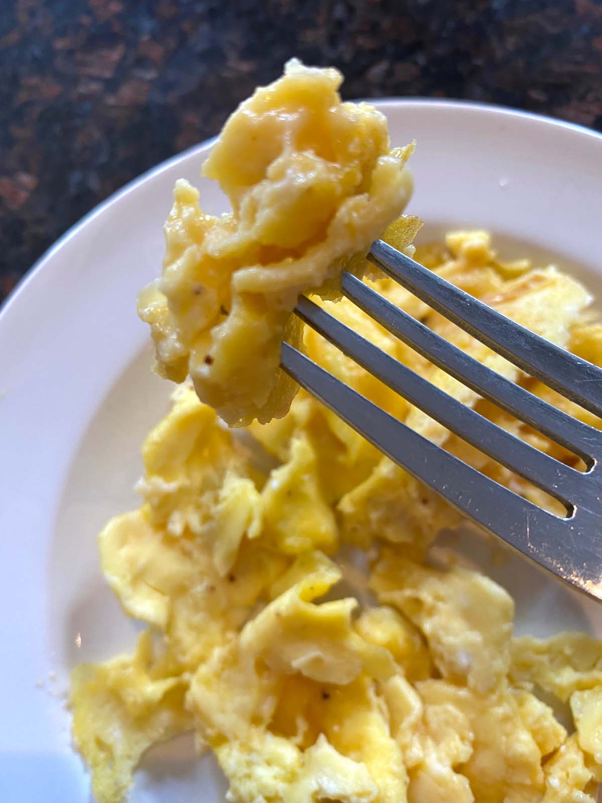 Scrambled eggs on a white plate.