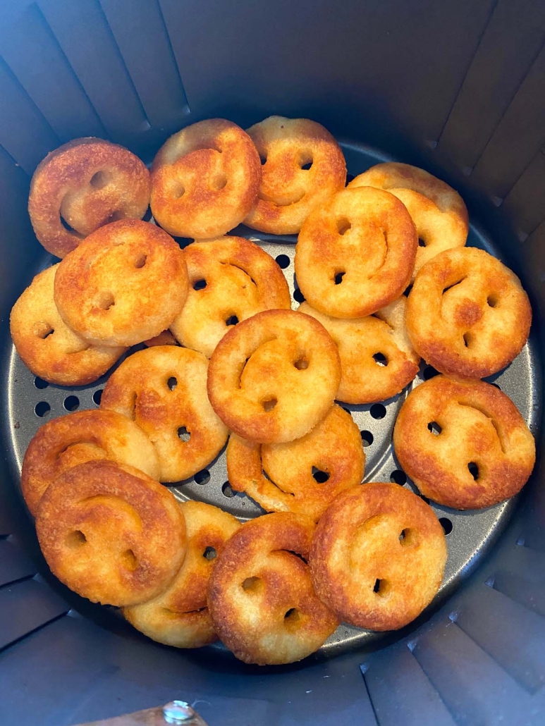 close up of air fried smiley fries in the air fryer