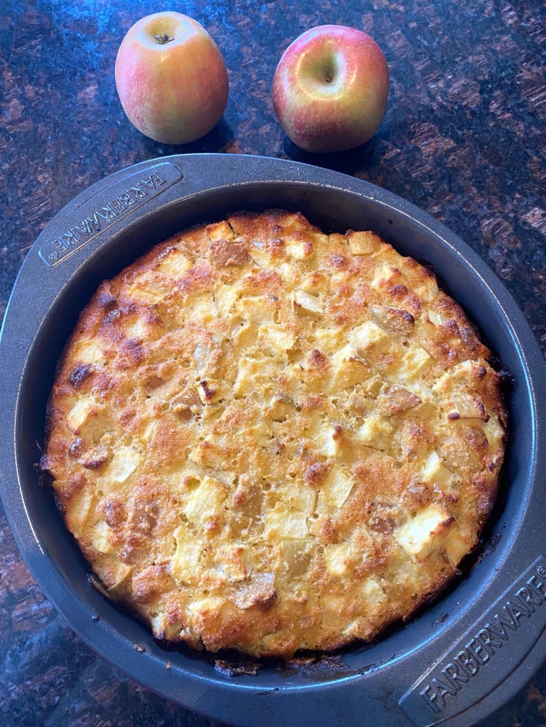 apples next to a gluten free apple cake sitting on the counter