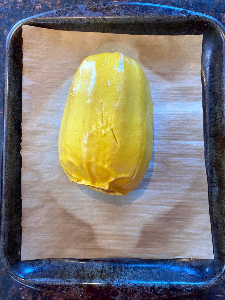 spaghetti squash on a baking sheet with parchment paper