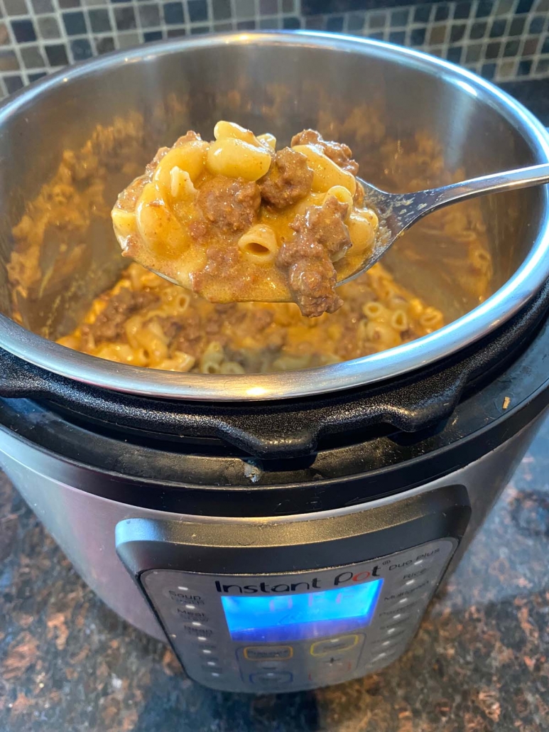 spoon scooping up cooked hamburger helper from the instant pot