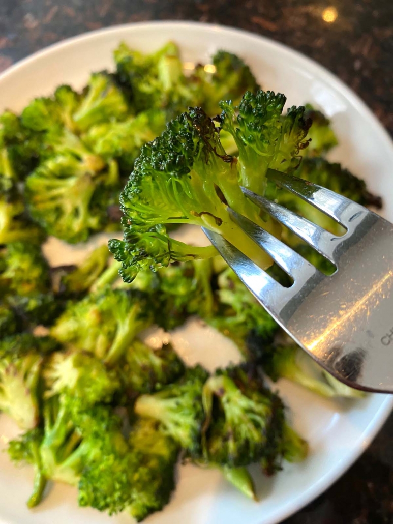 fork picking up broccoli from a plate