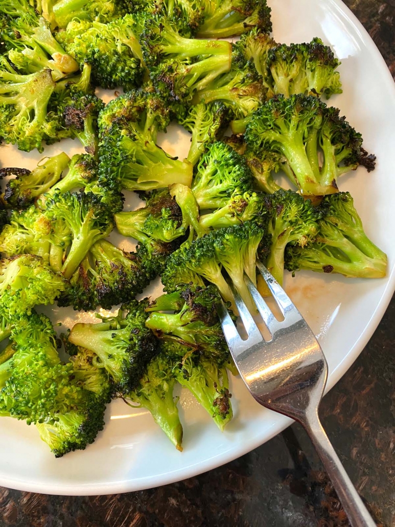 fork choosing a piece from a plate of sauteed broccoli