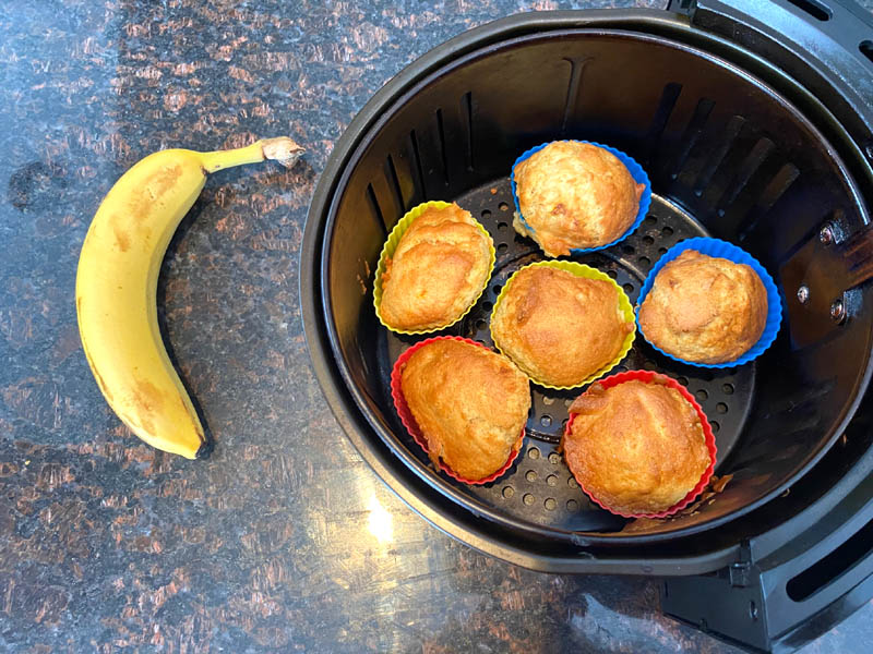 banana next to the air fryer with muffins cooked inside
