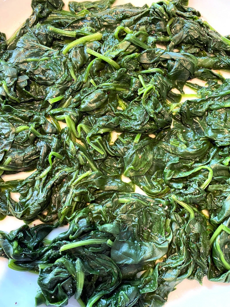 close up of cooked spinach on a plate