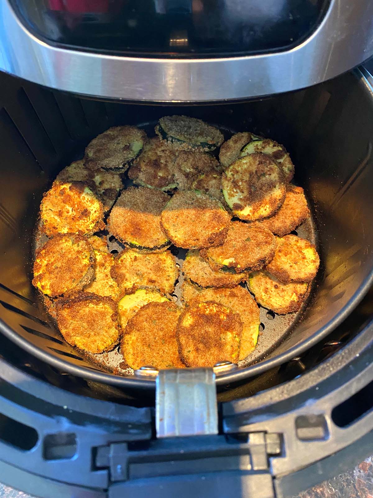 Cooked breaded zucchini in an air fryer.
