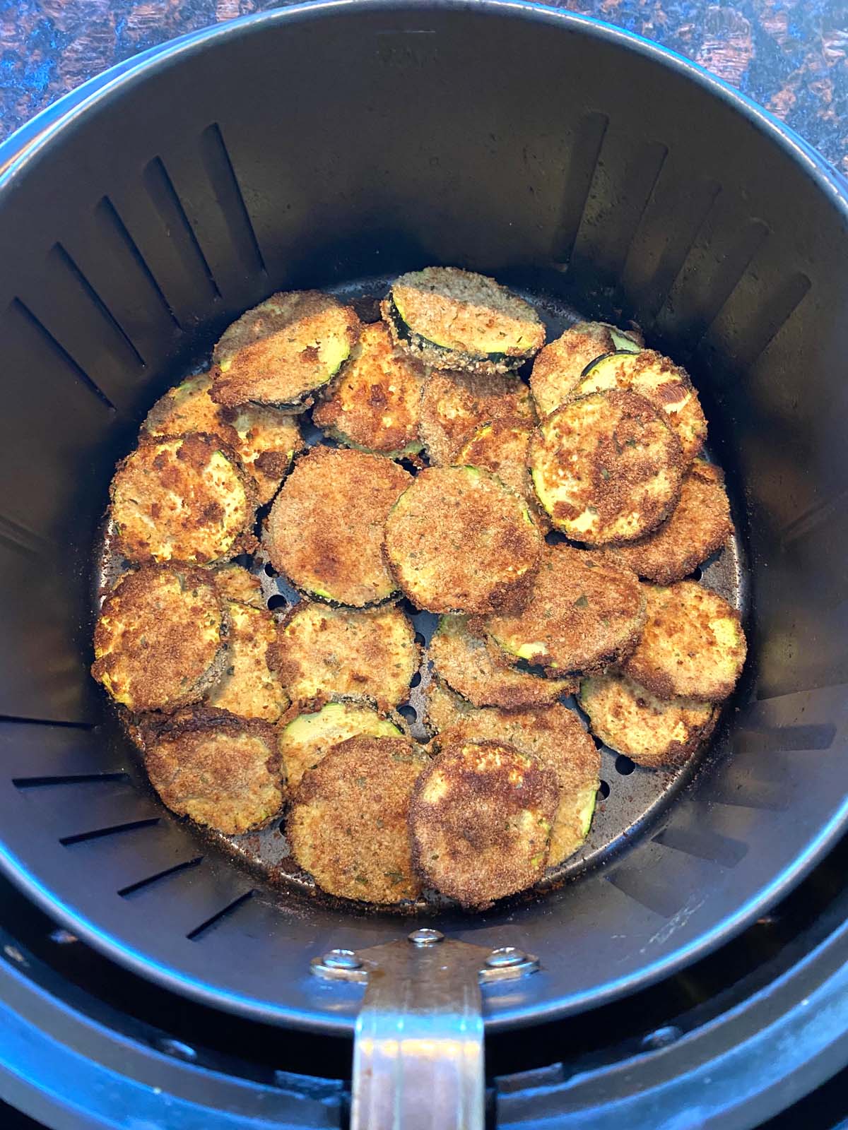 Cooked breaded zucchini in an air fryer.