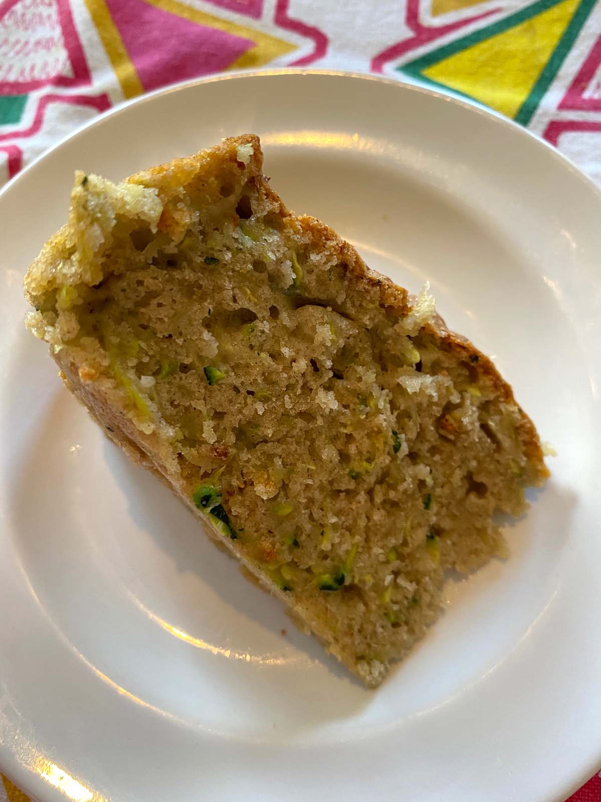 A slice of air fryer zucchini bread on a white plate.