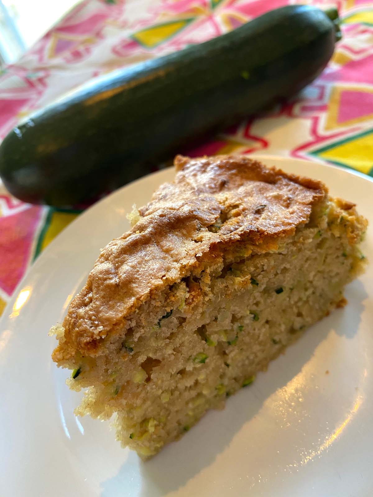 A slice of air fryer zucchini bread on a white plate.