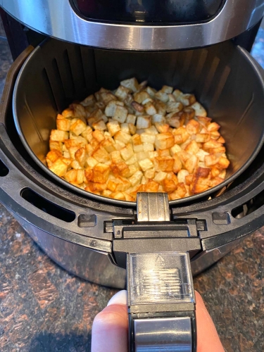 Cooked diced potatoes in an air fryer.