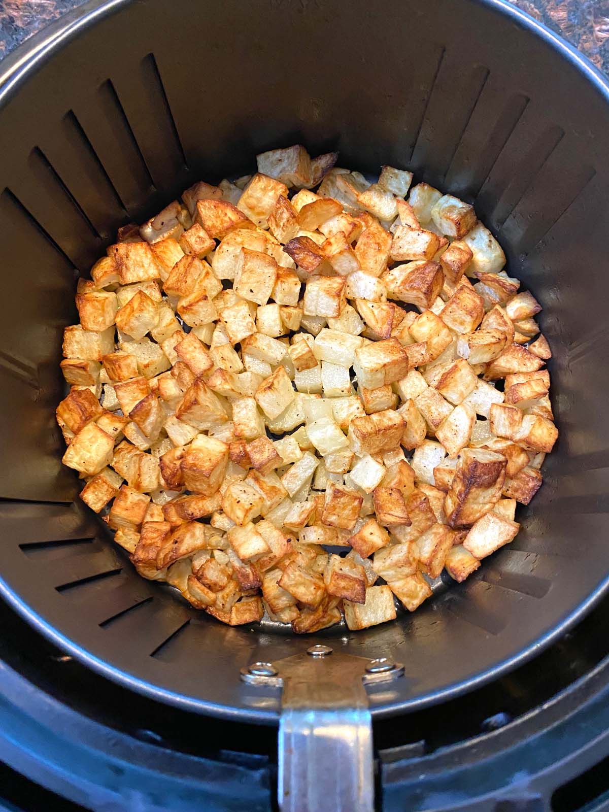 Cooked diced potatoes in an air fryer.