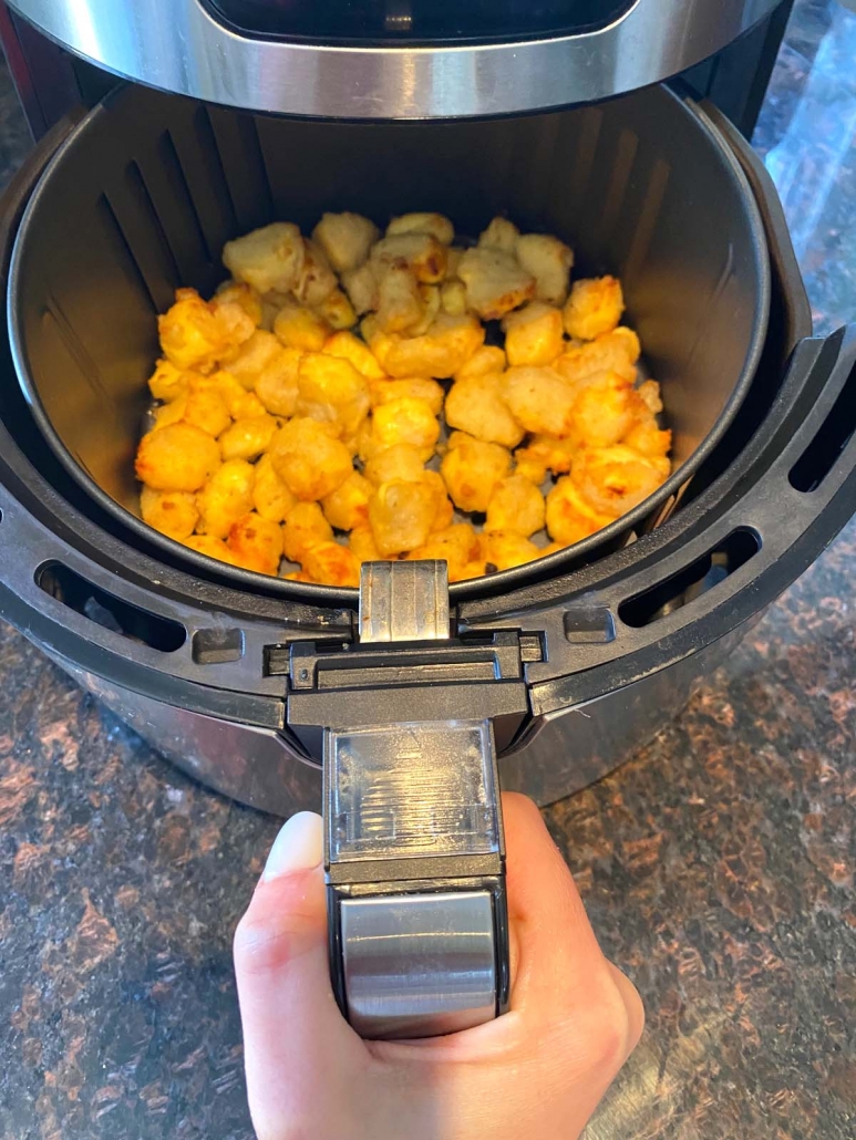 air fryer opened to show cooked cheese curds