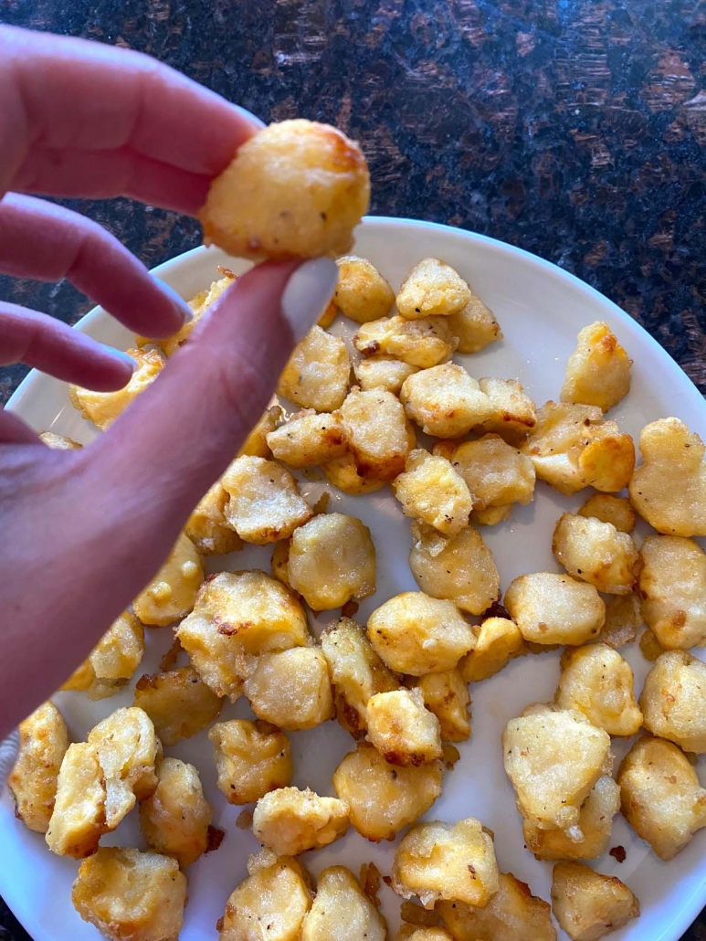 hand holding cooked cheese curd