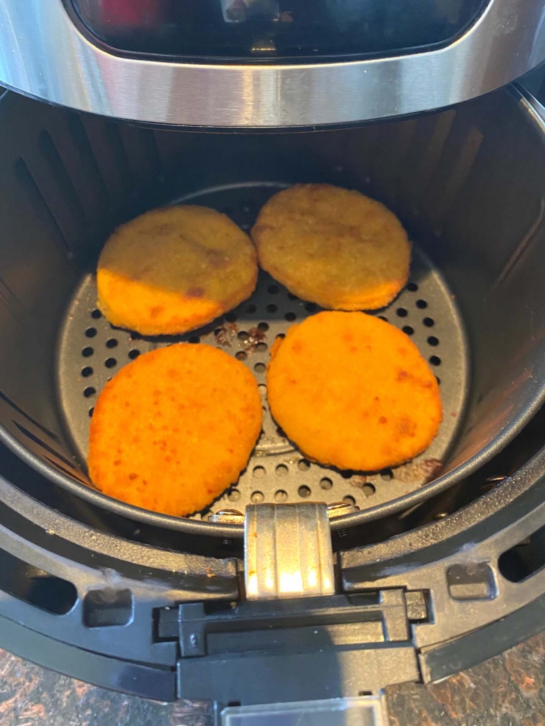 air fryer opened to show breaded chicken patties inside