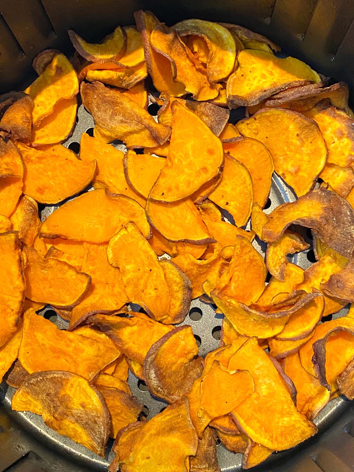 Cooked sweet potato chips in an air fryer.