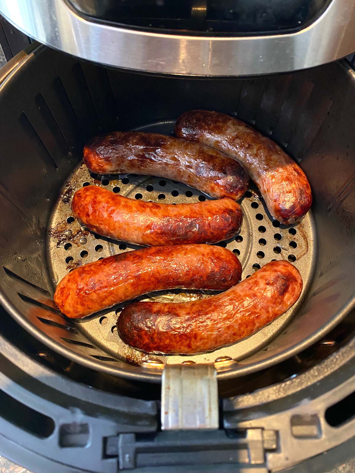 Cooked bratwurst in an air fryer.