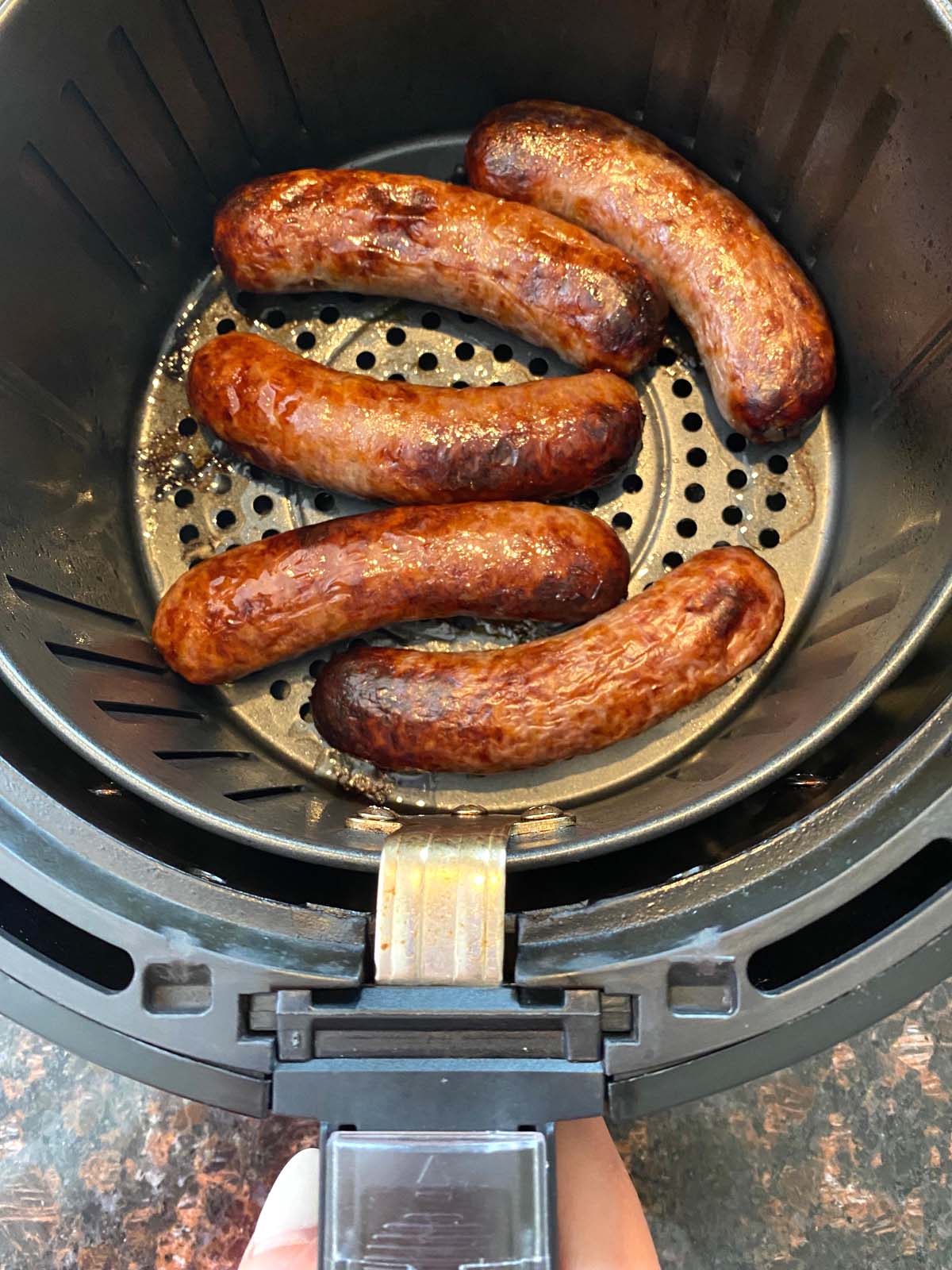 Cooked bratwurst in an air fryer.