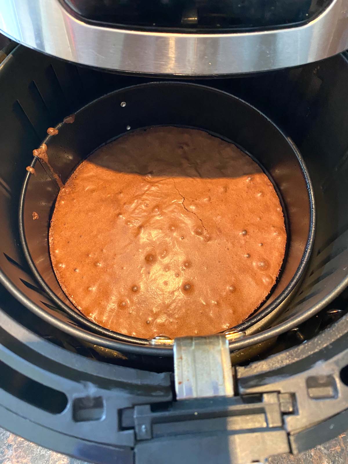 Basket of air fryer with cooked brownie being pulled out.