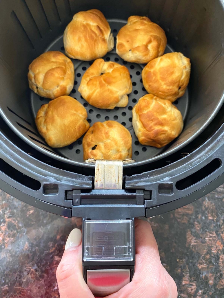 hand holding air fryer basket with oreos inside