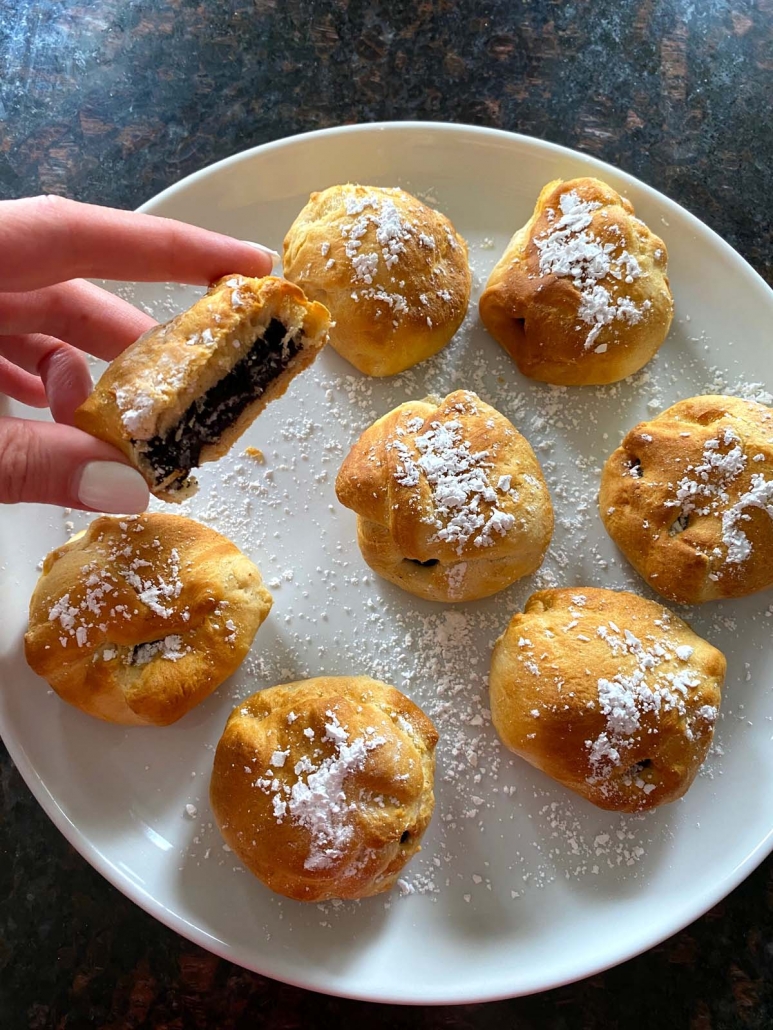 hand holding sliced air fried oreo with plate of oreos