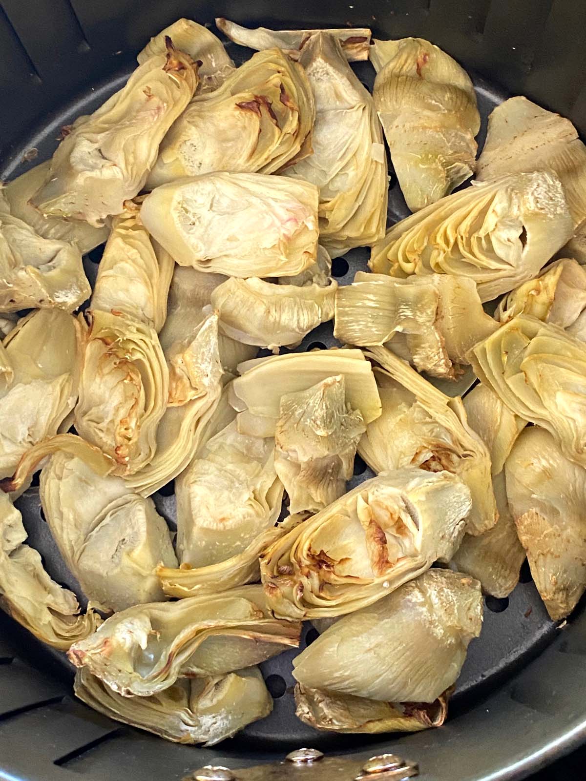 Cooked artichoke hearts in an air fryer.