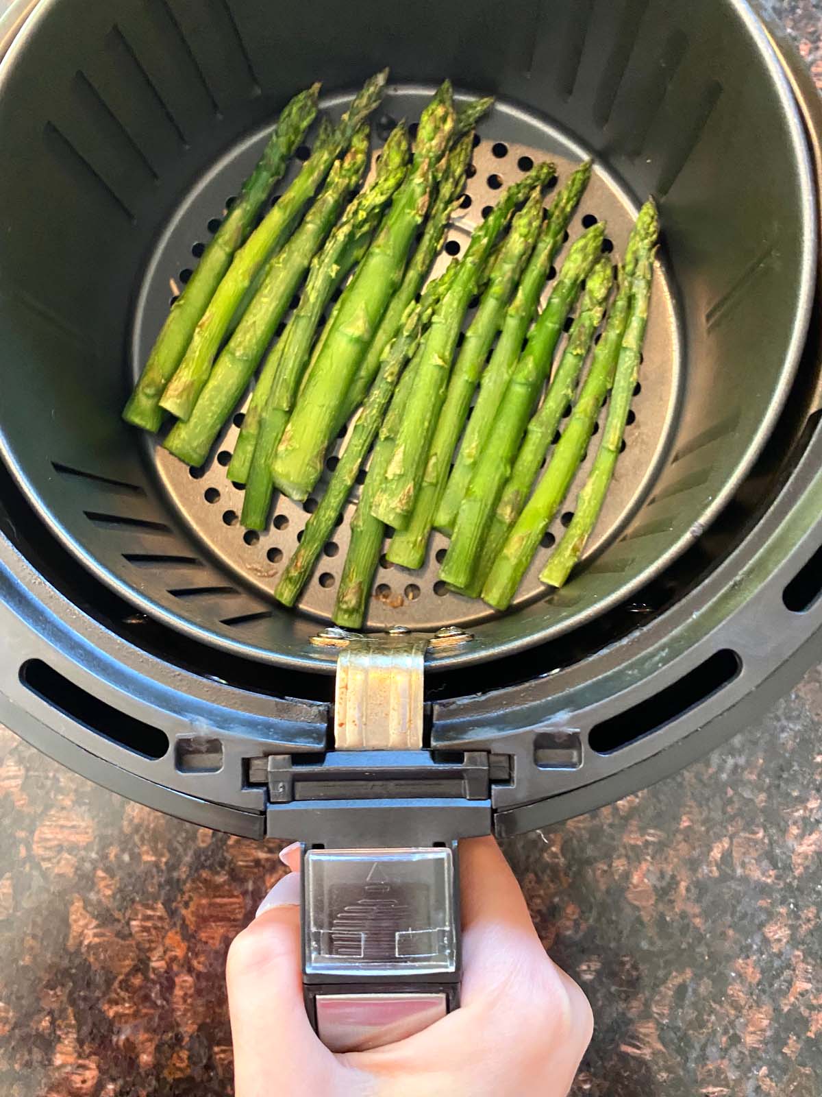 Cooked asparagus in an air fryer.