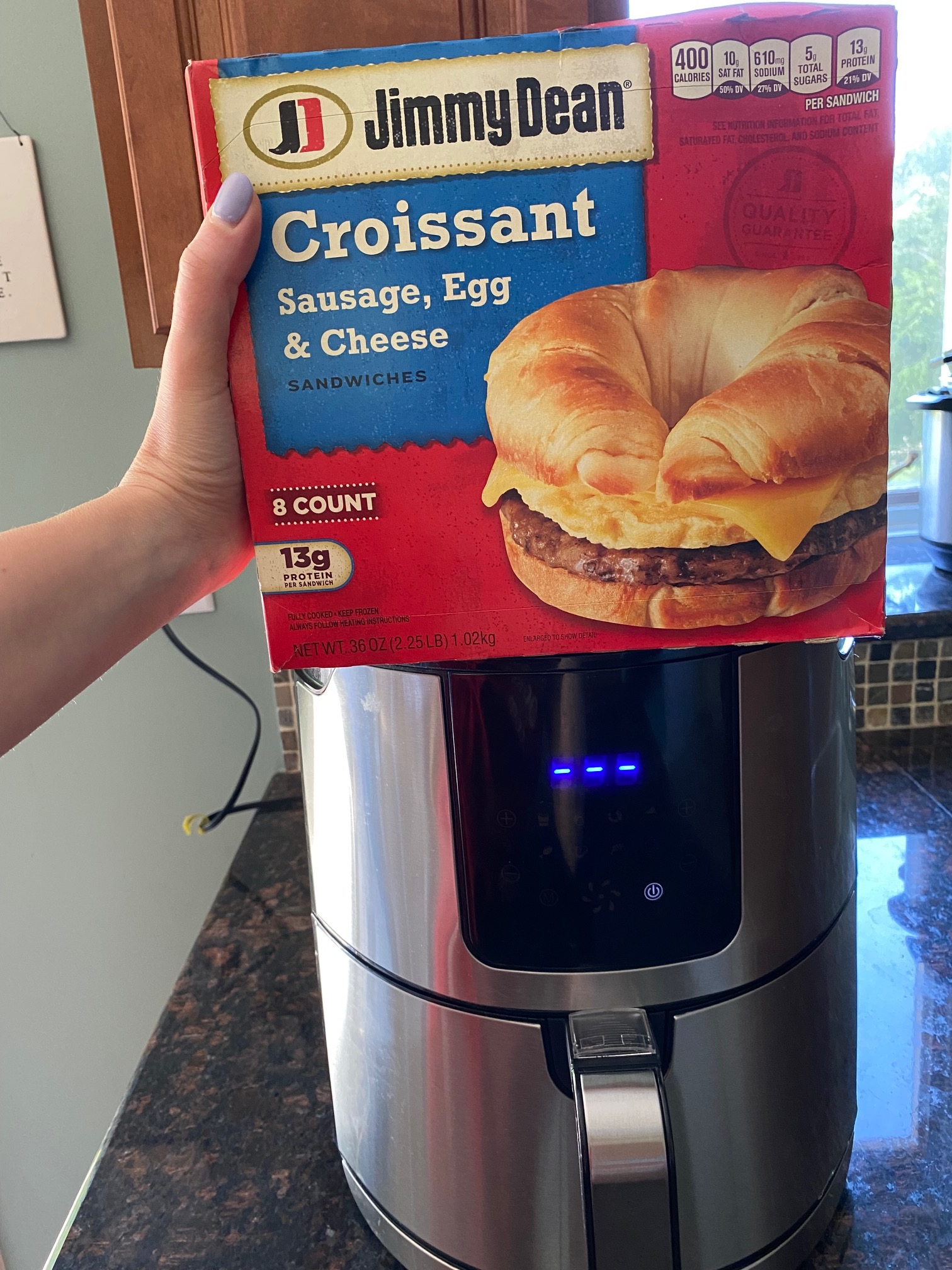 Box of frozen breakfast croissants in front of an air fryer.