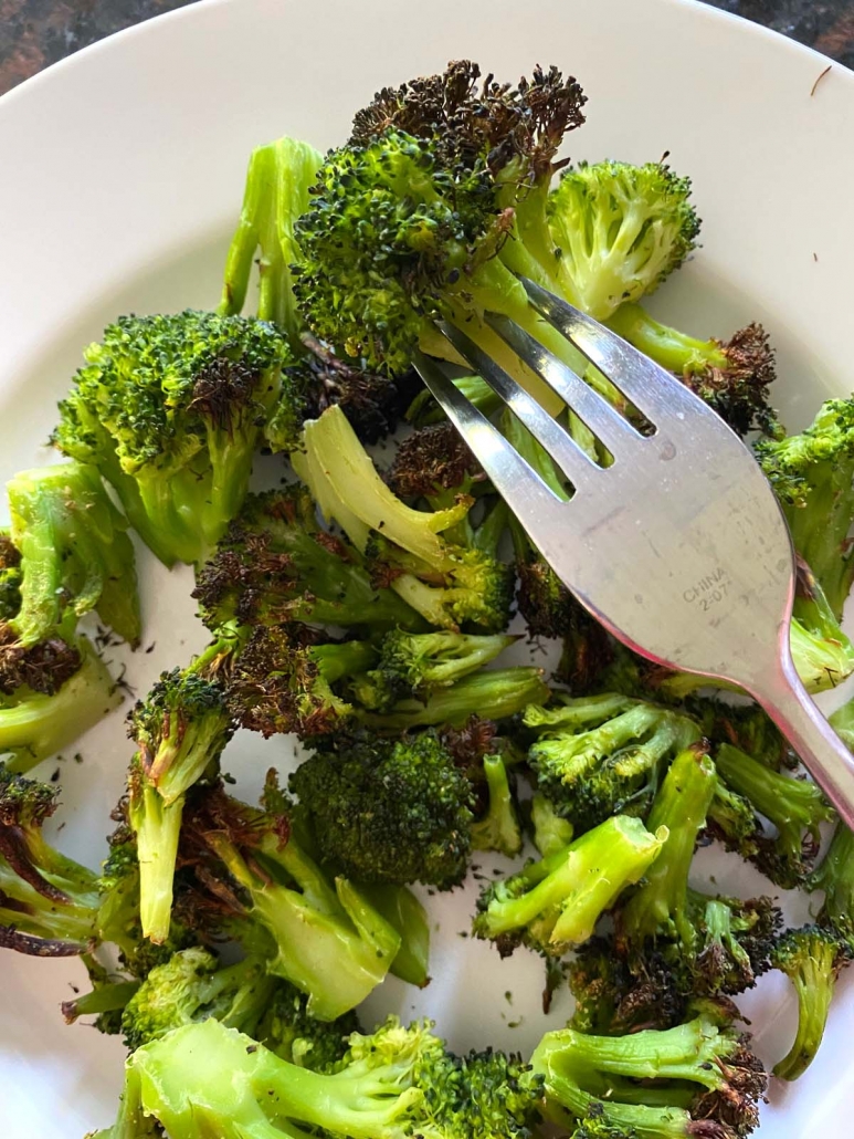 fork holding piece of cooked broccoli