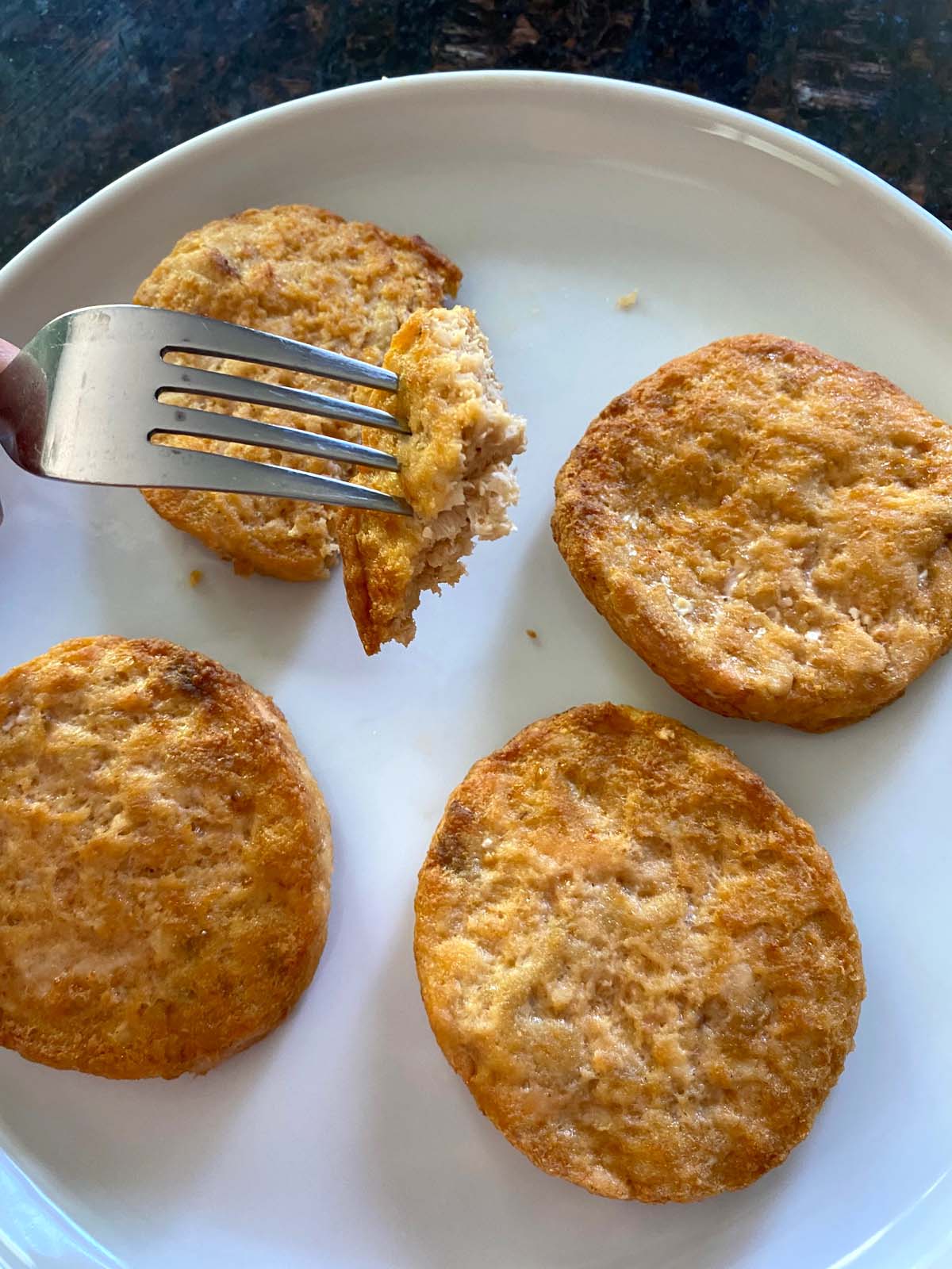 Cooked salmon burgers on a white plate. 