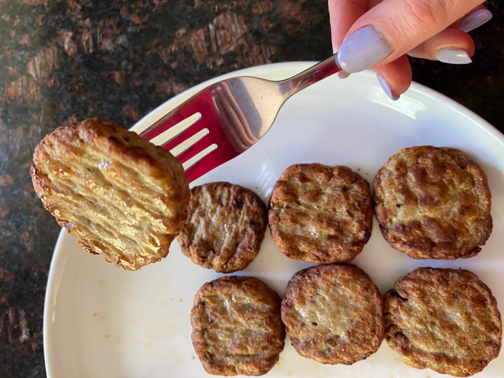 fork piercing a cooked breakfast sausage patty