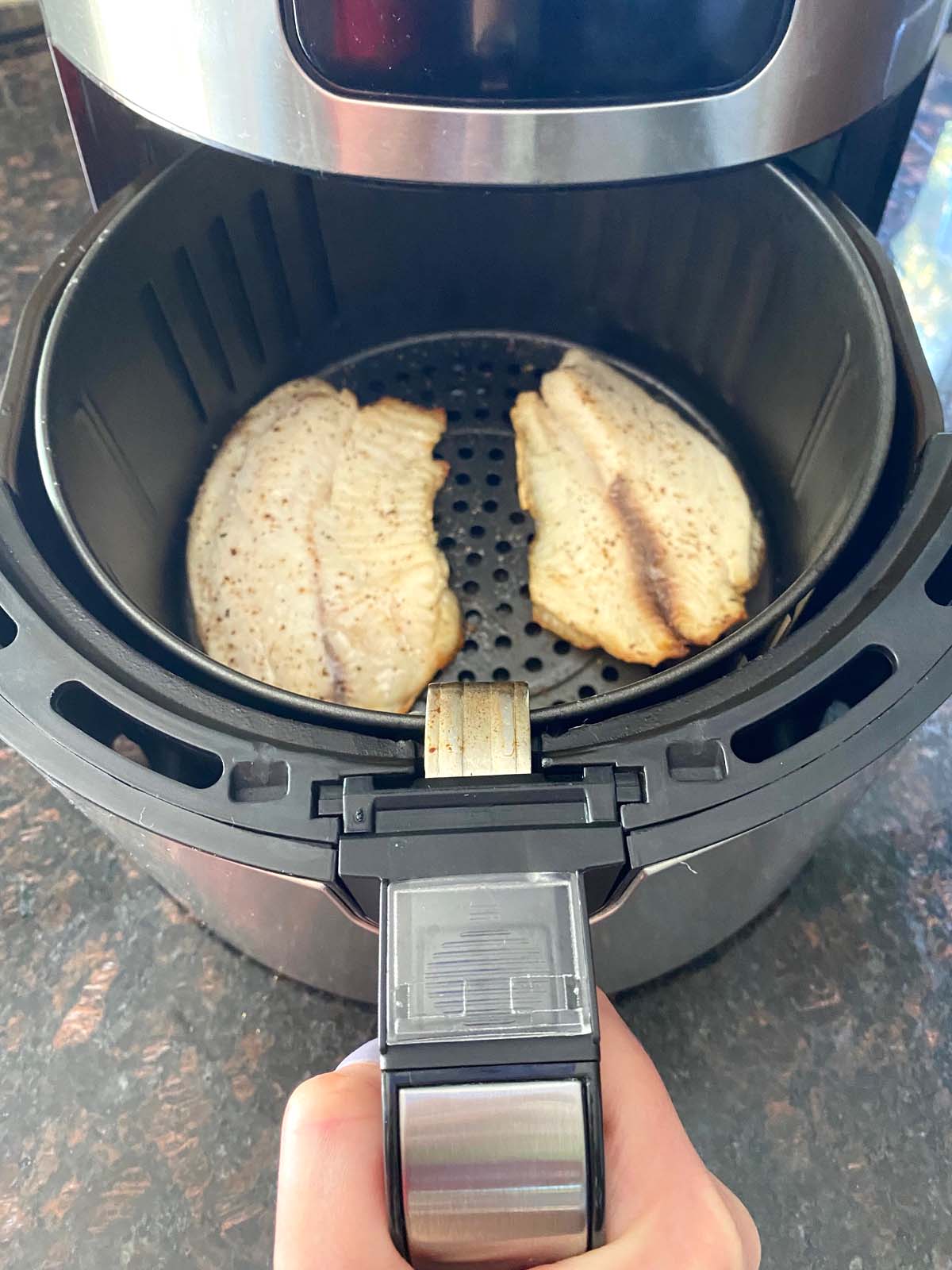 Cooked tilapia filets in an air fryer.