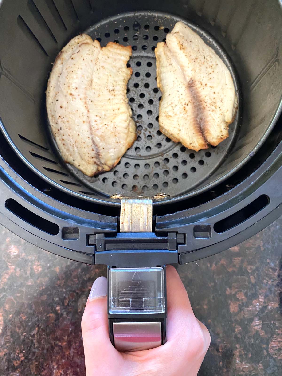 Cooked tilapia filets in an air fryer.