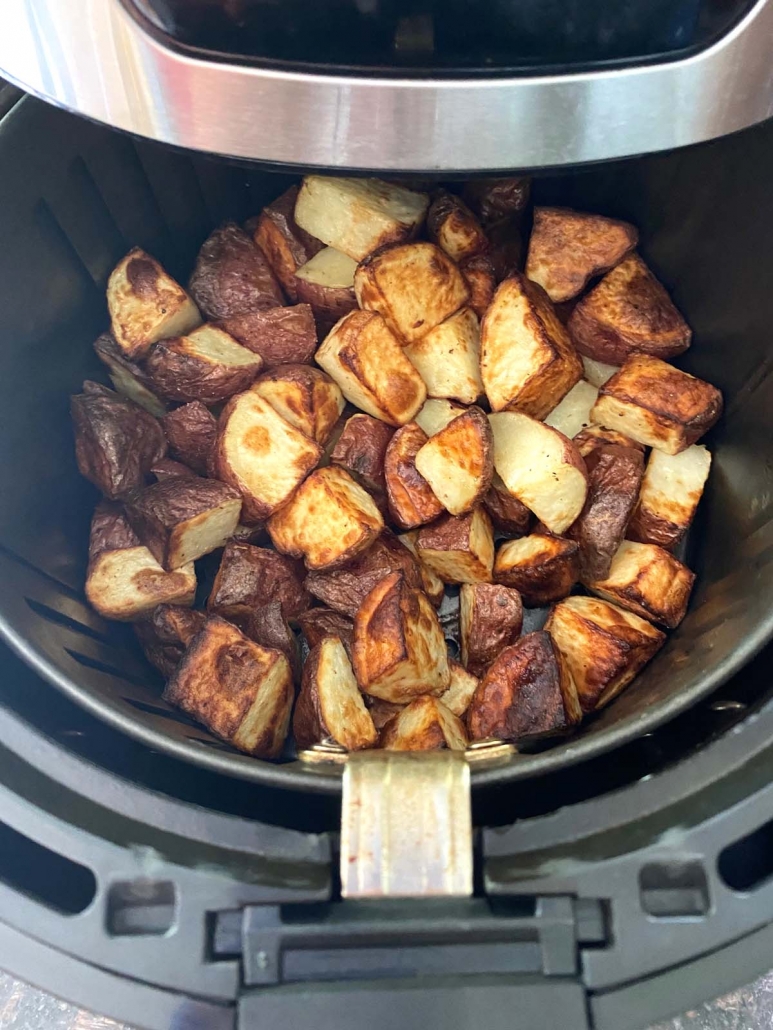 air fryer opened to show cooked potatoes