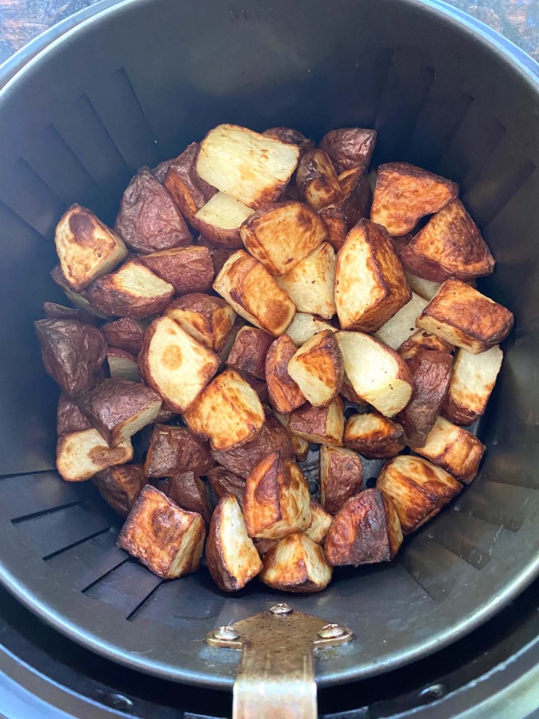 air fryer basket with red skin potatoes inside