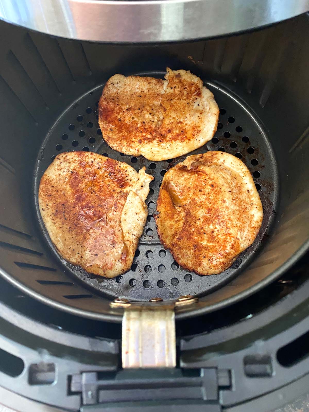 Close up of turkey chops in basket with seasoning.