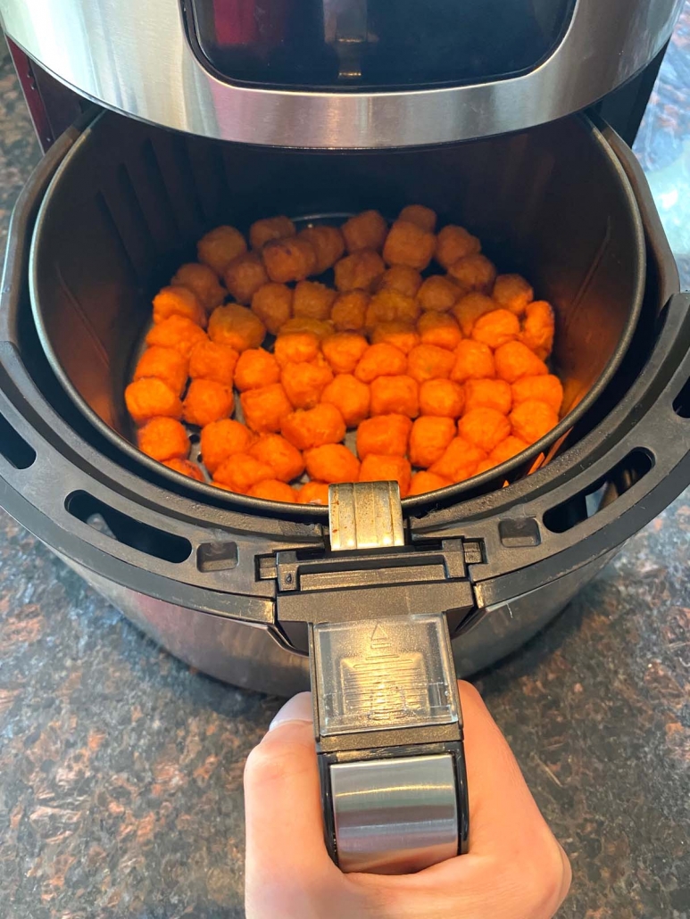 air fryer basket filled with frozen sweet potato puffs