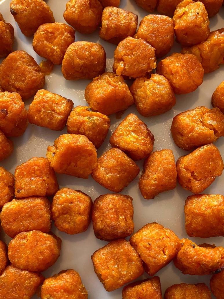 a close up view of air fried sweet potato puffs on a plate