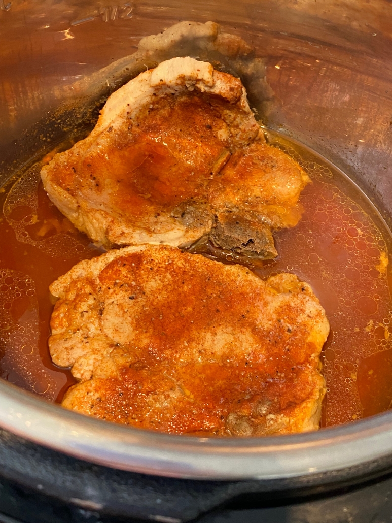 cooked and seasoned pork chops in the water at bottom of instant pot