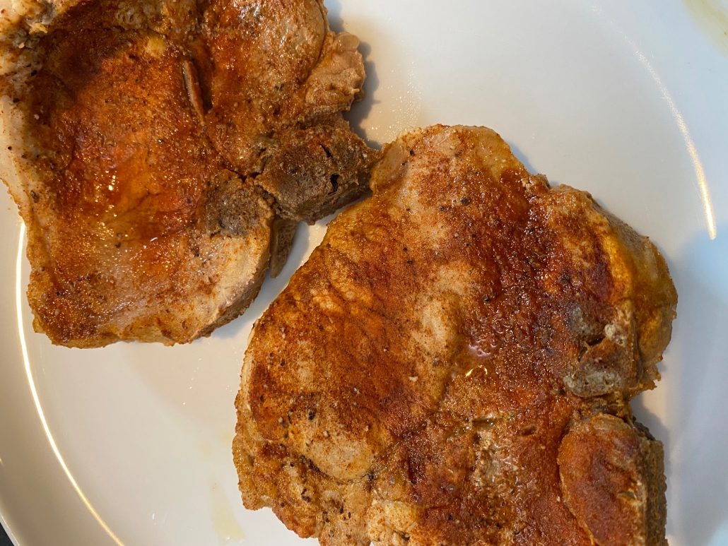 seasoned and cooked bone in pork chops on plate