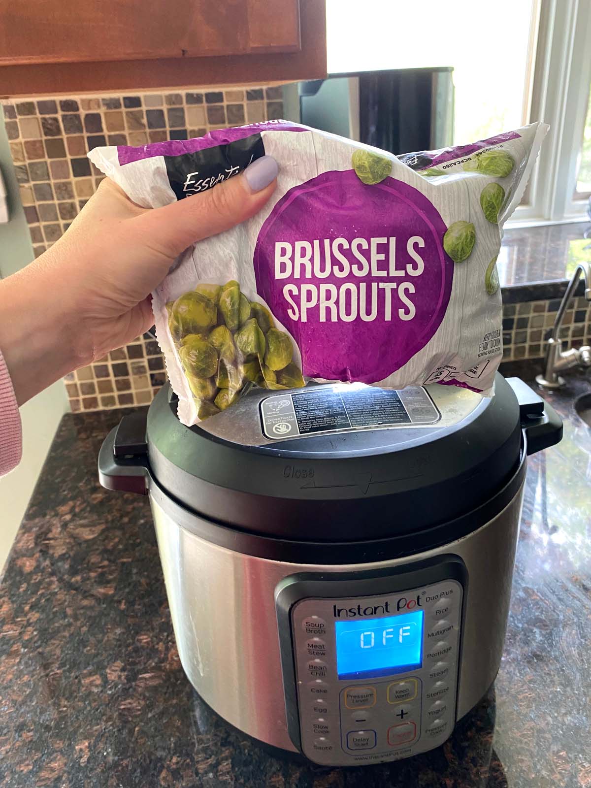 Bag frozen brussels sprouts in front of an Instant Pot. 