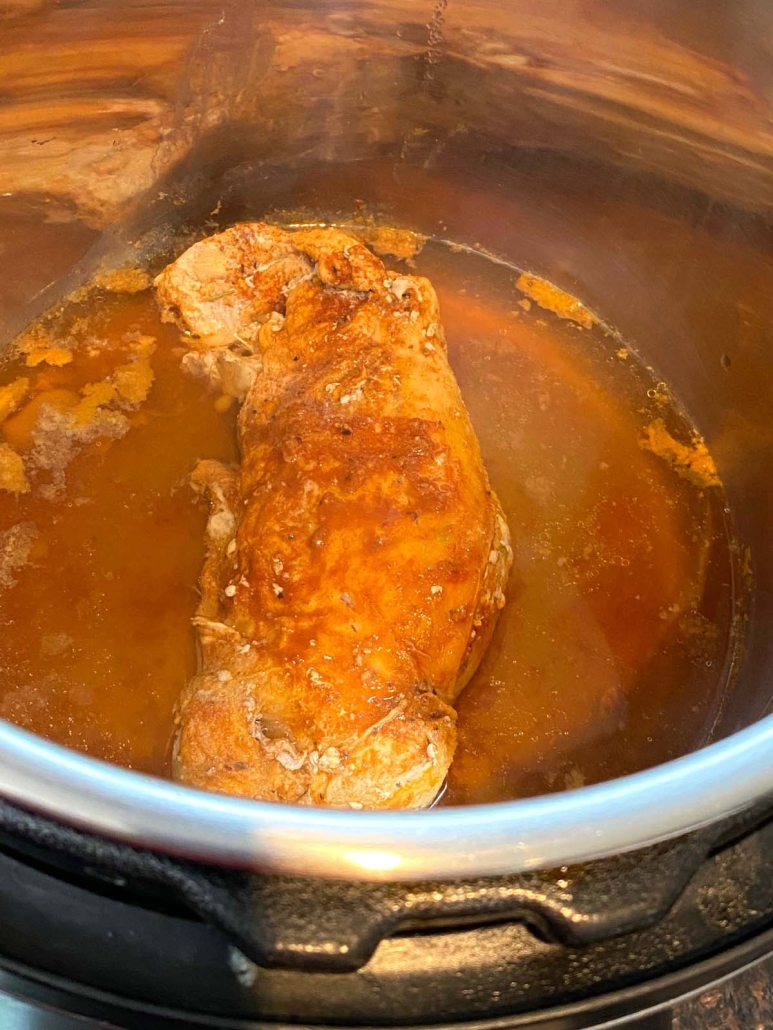 instant pot with seasoned pork tenderloin inside