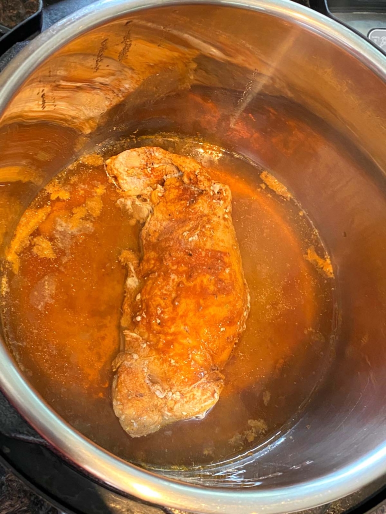 pressure cooker opened to show pork tenderloin