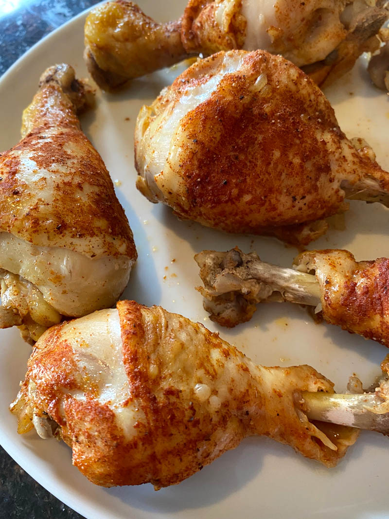 close up of chicken drumsticks on a plate.