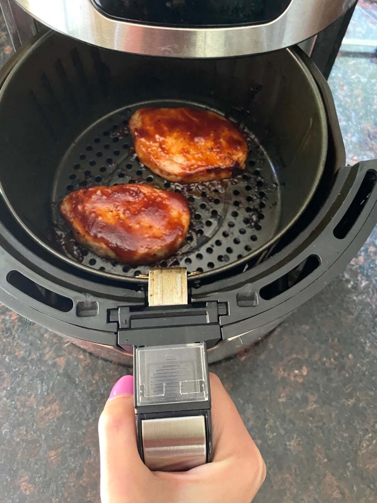 air fryer opened to show pork chops